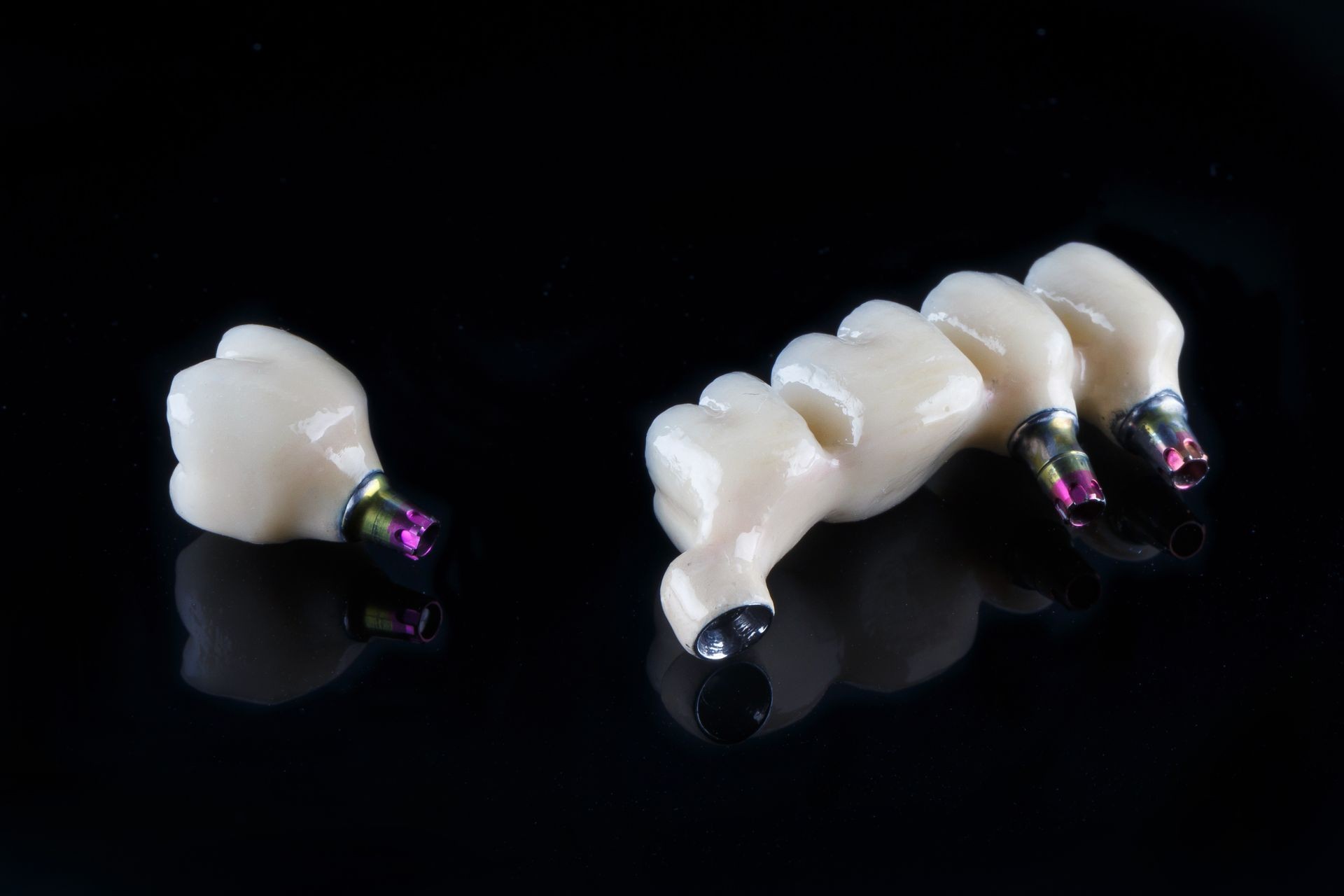  Ceramic Dental crowns, zirconia crown and four teeth on the black glass